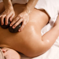 Therapist giving a hot stone massage to client